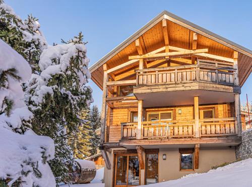 a log house with a balcony in the snow at Chalet Octopussy - LES GETS, jacuzzi, sauna, superbe vue in Les Gets