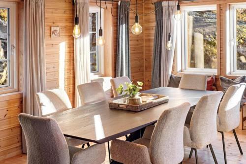 a dining room with a wooden table and chairs at Verhøf Hytte - 9p - With Sauna & Hot Tub in Vradal