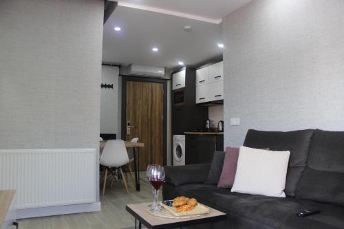 a living room with a couch and a wine glass at Cosy Suite in Antalya