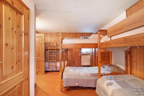 two bunk beds in a room with wooden walls at Casa Chamonin Pila in Gressan
