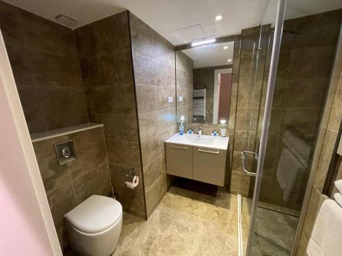 a bathroom with a toilet and a shower and a sink at Del Mare Aparthotel in Batumi