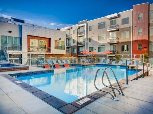 a large swimming pool with chairs and buildings at Modern Resort Styled 2BR Apt W Pool, Gym & Hot Tub in Salt Lake City