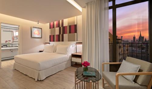 a hotel room with a bed and a balcony at H10 Cubik 4* Sup in Barcelona