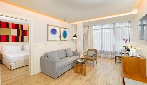 a living room with a couch and a bed in a room at H10 Cubik 4* Sup in Barcelona