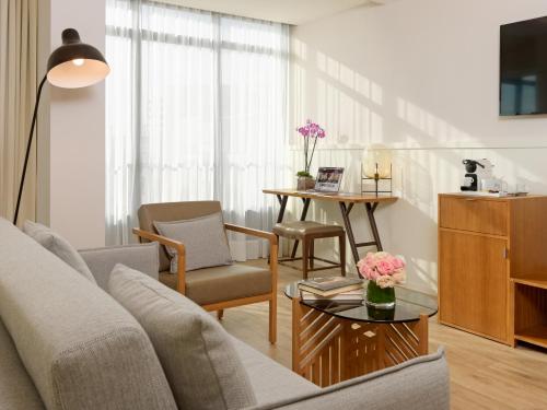 a living room with a couch and a table at H10 Cubik 4* Sup in Barcelona