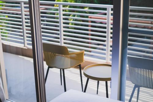 two chairs and a table on a balcony at Odysis Onna Resort Hotel in Onna