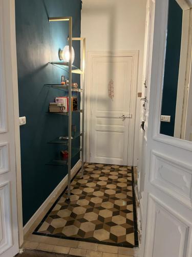 un couloir avec une porte et un sol en damier dans l'établissement Appartement cosy comédie, à Montpellier