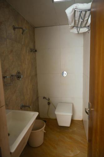 a bathroom with a tub and a toilet and a sink at Octave Hotel AM Garden in Bangalore