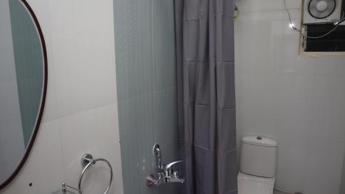 a bathroom with a shower and a toilet and a mirror at Dcasa Apartment Hotel in Hyderabad