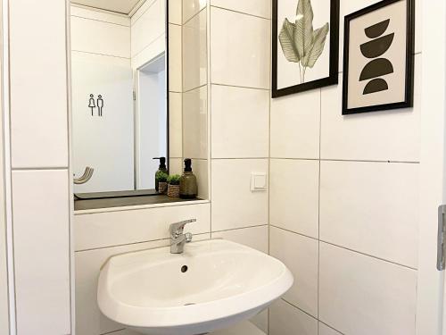 a white bathroom with a sink and a mirror at Große 6 Personen Wohnung I Balkon I zentral I Boxspringbett I Wifi in Hamm