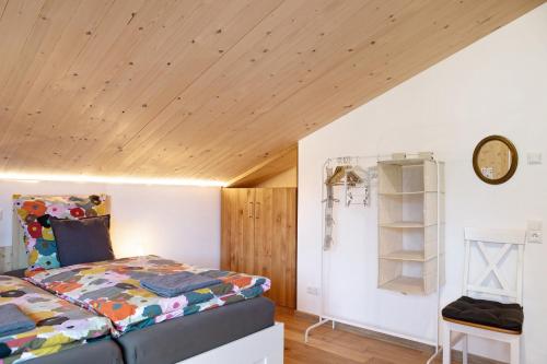 a bedroom with a bed and a wooden ceiling at Refugium aus Vollholz in Schlitz