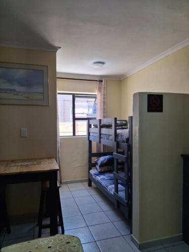 a room with bunk beds and a table and a desk at SUPA Lodge in Parow
