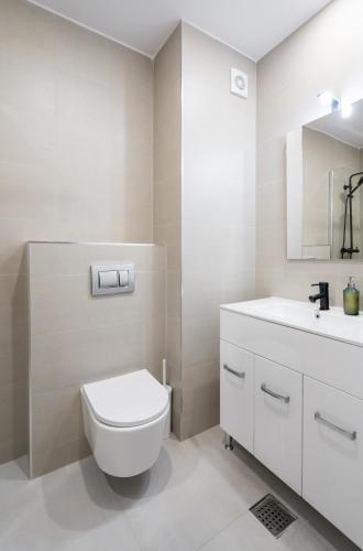 a white bathroom with a toilet and a sink at Springview Studio in Bucharest