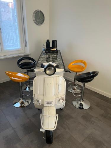 a white scooter parked next to a table withools at Estilenuevo Fashion Rooms in Druento