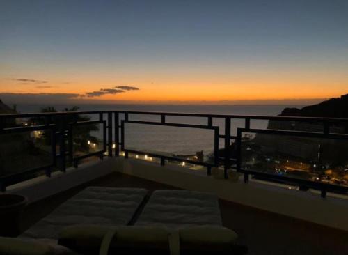 a view of the ocean from a balcony at sunset at Sunny Seaview Modern apt - pool and beach access in Taurito