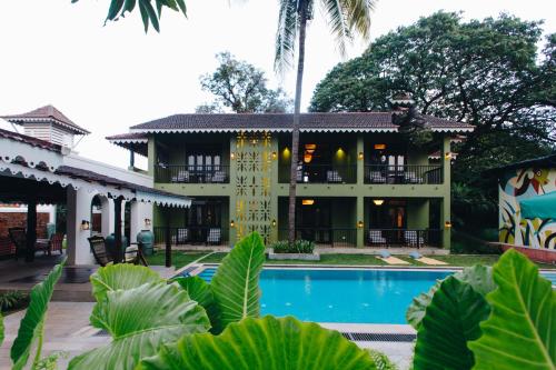 a house with a swimming pool in front of it at The Project Cafe and Hotel in Aldona