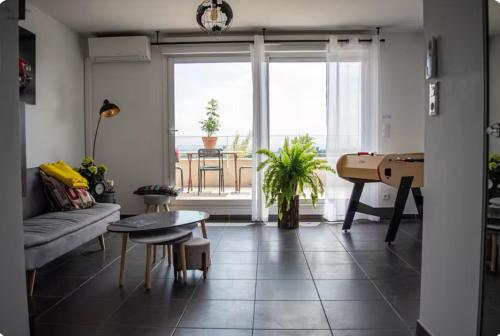 - un salon avec un canapé, une table et un piano dans l'établissement Appt Standing Rooftop proche Montpellier, à Juvignac