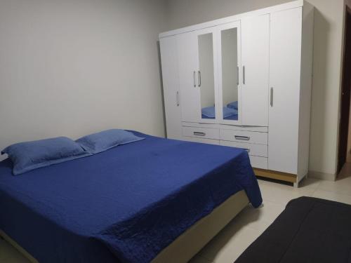 a bedroom with a blue bed and a white cabinet at Casa agradável e confortável, com piscina in Bonito