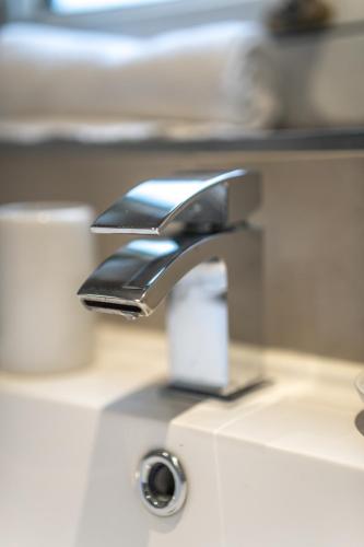 a bathroom sink with a faucet on a counter at Skye House in Grangemouth