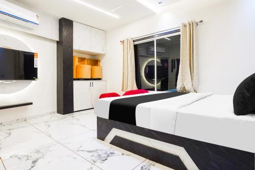 a bedroom with two beds and a flat screen tv at Hotel O SR & Guest House 2 in Sakardarā