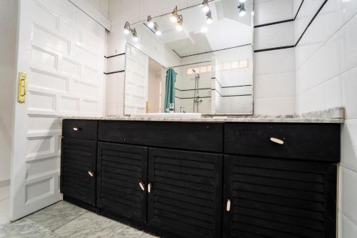 y baño con tocador negro y espejo. en Villasun sunset, en Villajoyosa