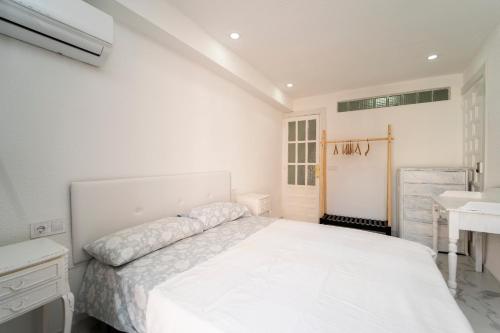 1 dormitorio blanco con 1 cama grande y lavamanos en Villasun sunset, en Villajoyosa