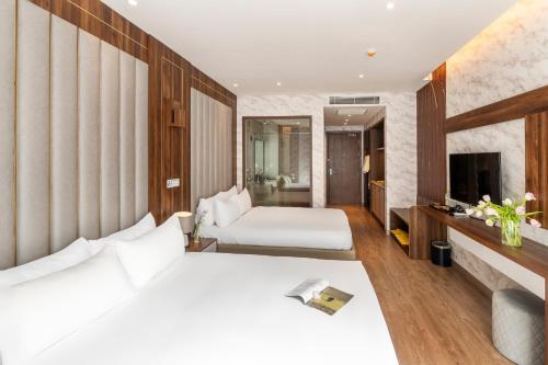 a hotel room with a bed and a television at Apec Mandala Mũi Né Resorts & Hotels NN in Phan Thiet