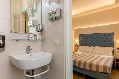 a bathroom with a sink and a bed at Hotel Italia Boutique in Rimini