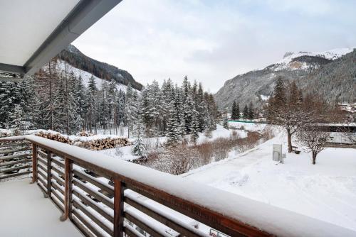 a snow covered balcony with a view of the mountains at Guesthouse Canazei Cozy 2-Bedrooms in Canazei