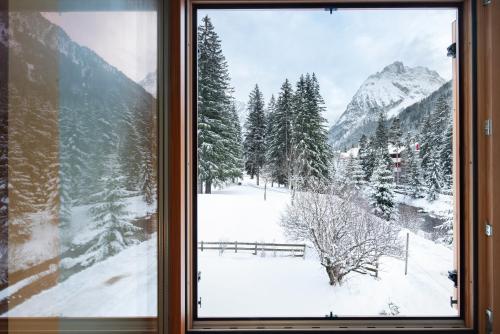 a window with a view of a snow covered mountain at Guesthouse Canazei Cozy 2-Bedrooms in Canazei