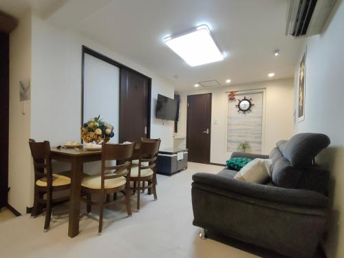 a living room with a couch and a table and chairs at promotion 12全新装修 3室1厅2浴室2卫生间 设施齐全 最大7人 3 rooms 1dining room 2 bathrooms 2toilets Max 7P 免费无线网络 in Tokyo