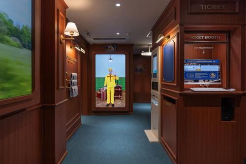 a hallway of a train with a man in a suit at Stay Passport Express Spa Dangsan in Seoul