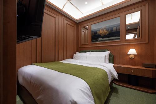 a bedroom with a bed with a television in it at Stay Passport Express Spa Dangsan in Seoul