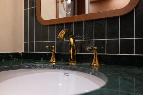 a bathroom sink with a gold faucet at Stay Passport Express Spa Dangsan in Seoul