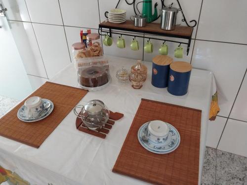 a table with two plates and cups on it at Casa Inteira in Diamantina-MG in Diamantina
