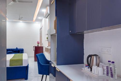 a kitchen with blue cabinets and a bed in a room at Limewood Stay - Sector 29 Gurgaon in Gurgaon