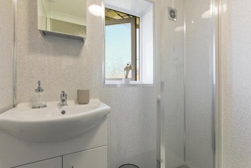 a white bathroom with a sink and a shower at Leconfield Close - Comfy house and free parking in Hull