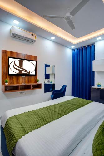 a bedroom with a bed and a tv on a wall at Limewood Stay - Sector 29 Gurgaon in Gurgaon