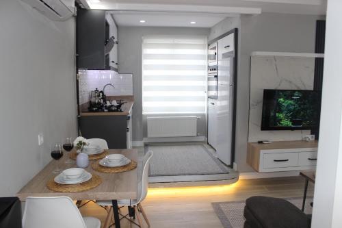 a kitchen and dining room with a table and a television at Cosy Suite in Antalya