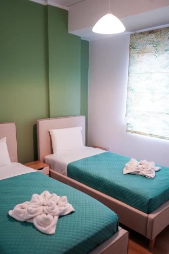 two beds in a room with towels on them at Rianos in Nafplio