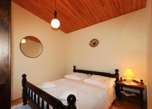 a bedroom with a bed and a table with a lamp at Pisak holiday homes in Pisak