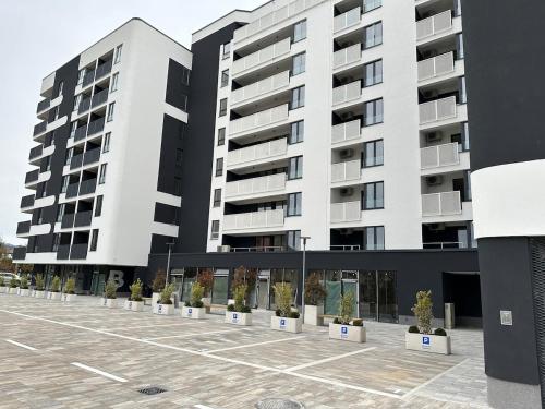 a large white building with potted plants in a parking lot at New apartment in Sarajevo