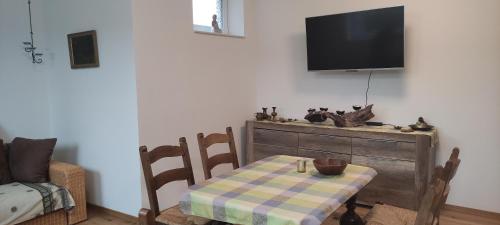 a room with a table and a tv on a wall at Rheinufer in Xanten