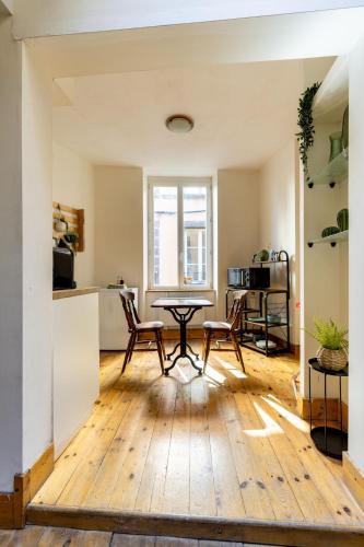 une cuisine et un salon avec une table et des chaises dans l'établissement Cosy & Duplex - Appartements au coeur de la vieille Ville, à Clermont-Ferrand