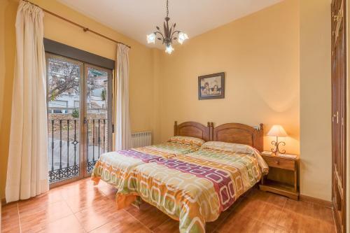 een slaapkamer met een bed en een raam bij Apartamentos Haza La Moraleda 2 y A in Güéjar-Sierra