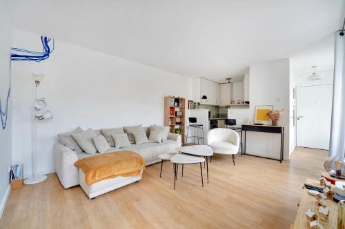 un salon avec un canapé blanc et une cuisine dans l'établissement L'Alegria - Paris - Marais - 4 prs, à Paris