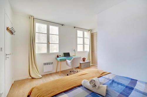 une chambre avec un lit et un bureau avec un ordinateur dans l'établissement L'Alegria - Paris - Marais - 4 prs, à Paris