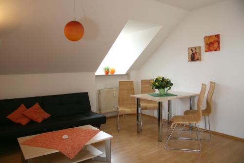 a living room with a black couch and a table at Hotel Linner in Erding