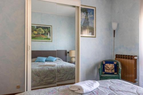 a mirror in a bedroom with a bed and a chair at Casa Giulia, Darfo Boario Terme Ospitar in Darfo
