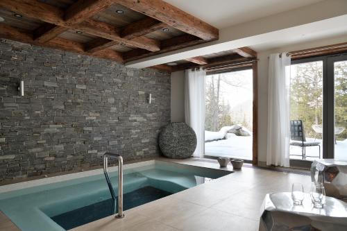 une baignoire dans une pièce avec un mur en pierre dans l'établissement Chalet Labaobou Courchevel 1650, à Courchevel